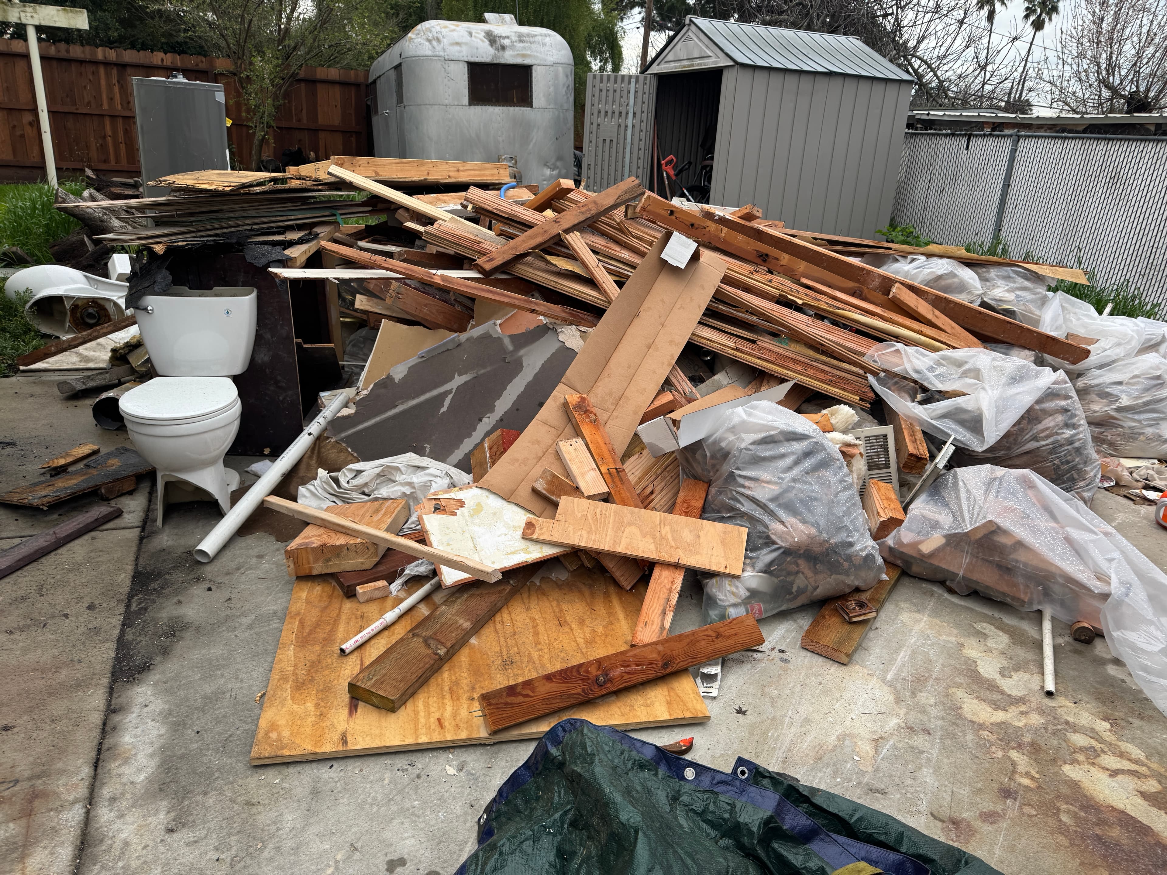 Driveway covered in demolition debris before Servant King cleanup